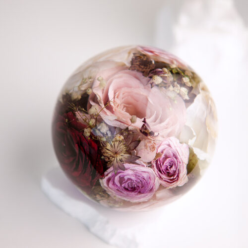 Konservierter Brautstrauß mit lila und weißen Rosen in Epoxidharz-Kugel auf weißem Marmorsockel - Brautstraußkonservierung Flomory
