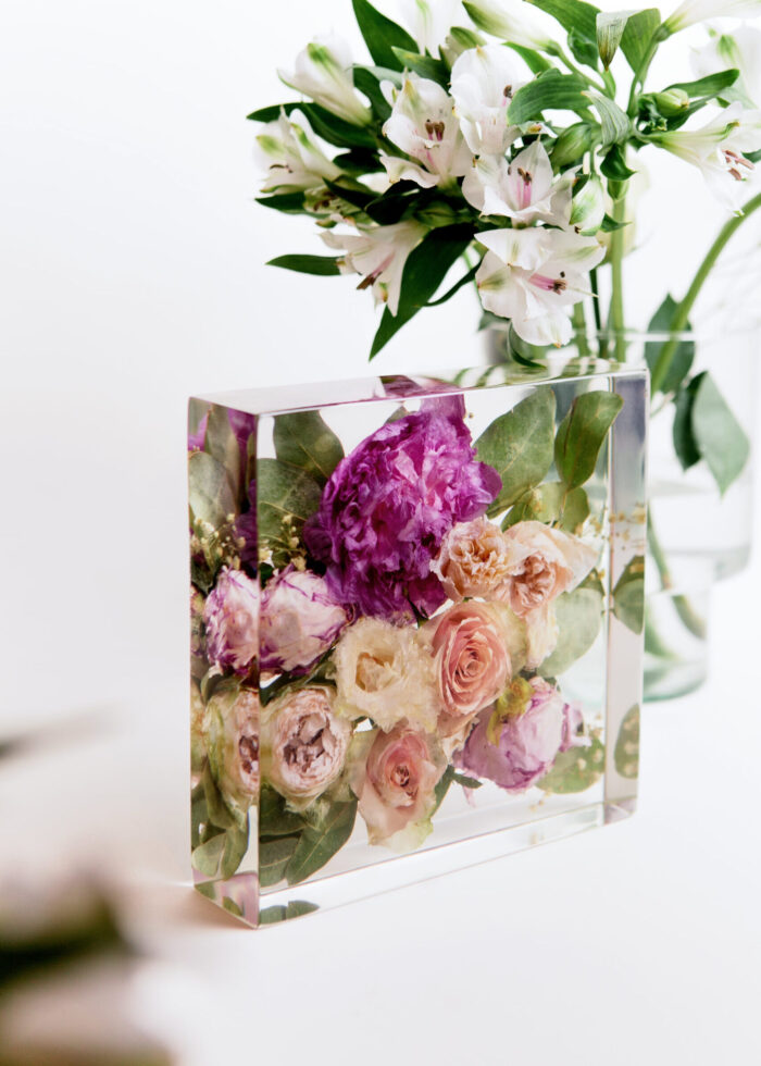 Konservierter Brautstrauß in transparentem Kunstharz-Block mit rosa Pfingstrosen, cremefarbenen Rosen und grünen Blättern, Brautstrauß-Konservierung